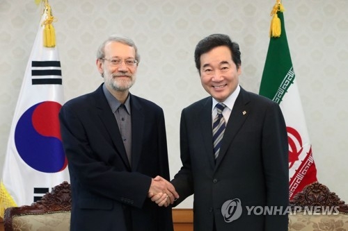 This photo, taken on June 28, 2017, shows South Korea's Prime Minister Lee Nak-yon (R) shaking hands with Iranian parliamentary speaker Ali Larijani before their talks at Lee's office in Seoul. (Yonhap)