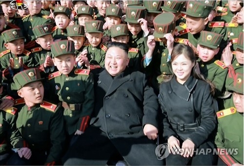 This photo, released by the North's Korean Central Television on March 3, 2017, shows North Korean leader Kim Jong-un and his wife Ri Sol-ju meeting students of the Red Flag Mangyongdae Revolutionary School in Pyongyang. (For Use Only in the Republic of Korea. No Redistribution) (Yonhap)