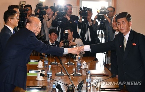 This photo taken by joint press corps shows Park Kyung-seo (L), South Korea's chief delegate, shaking hands with his North Korean counterpart Pak Yong-il (R) before the start of inter-Korean Red Cross talks at a hotel at Mount Kumgang on the North's east coast on June 22, 2018. (Yonhap)