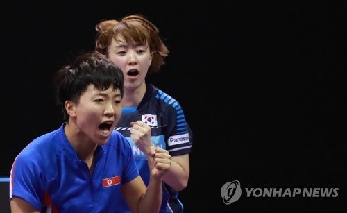 Kim Song-i of North Korea (L) and Suh Hyo-won of South Korea react to their point against Wang Manyu and Zhu Yuling of China in the women's doubles round of 16 match at the International Table Tennis Federation (ITTF) World Tour Platinum Korea Open at Chungmu Sports Arena in Daejeon, 160 kilometers south of Seoul, on July 19, 2018. (Yonhap)