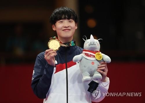 South Korean taekwondo fighter Lee Da-bin shows her gold medal after winning the women's over-67 kilogram division taekwondo "kyorugi" (sparring) competition at the 18th Asian Games in Jakarta on Aug. 21, 2018. (Yonhap)