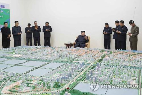 A photo released by the Rodong Sinmun on Nov. 16, 2018, shows North Korean leader Kim Jong-un guiding the master development plan of Sinuiju during his visit to the border city. (For Use Only in the Republic of Korea. No Redistribution) (Yonhap)
