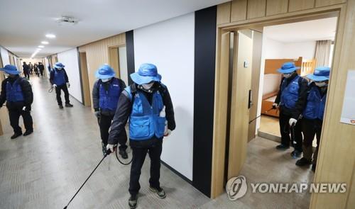 Workers at a youth hostel in Suwon, 46 kilometers south of Seoul, disinfect a room on Feb. 17, 2020, that will be used as a temporary self-quarantine facility by people suspected of having contracted the novel coronavirus. (Yonhap)