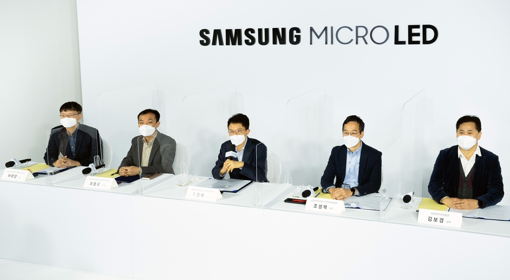 This photo provided by Samsung Electronics Co. on Dec. 10, 2020, shows company executives explaining Samsung's new 110-inch Micro LED TV at an online event in South Korea. (PHOTO NOT FOR SALE) (Yonhap) 