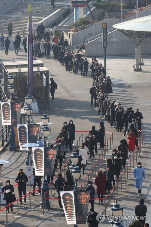 People stand in a long line to take coronavirus tests at a temporary screening center in front of Seoul Station in central Seoul on Dec. 21, 2020. (Yonhap)