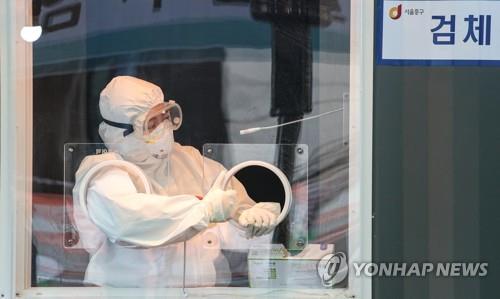 A medical worker waits for visitors to come for coronavirus tests at a makeshift clinic at the plaza in front of Seoul City Hall on Jan. 14, 2021. (Yonhap)