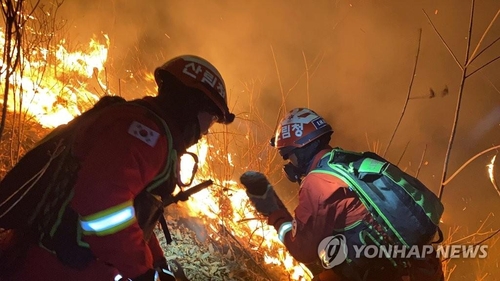 Firefighters conduct operations to extinguish a forest fire in Jeongseon, some 210 kilometers east of Seoul, on Feb. 21, 2021, in this photo provided by the Korea Forest Service. (PHOTO NOT FOR SALE) (Yonhap)