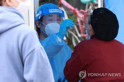 A health worker conducts COVID-19 tests at a temporary testing site in the southern ward of Guro on Oct. 30, 2021. (Yonhap)