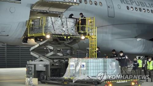 Workers unload boxes of aqueous urea solution from the Air Force's KC-330 tanker aircraft at Gimhae International Airport in the southeastern city of Busan on Nov. 11, 2021, in this photo provided by the Air Force. The plane brought 27,000 liters of urea solution from Australia as part of government efforts to ease a supply shortage of the key additive for diesel vehicles. (PHOTO NOT FOR SALE) (Yonhap)