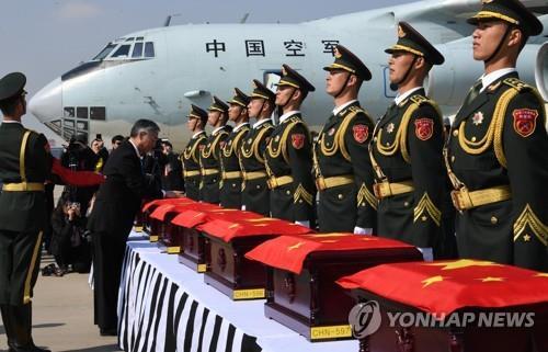In this file photo taken April 3, 2019, then Chinese Ambassador to South Korea Qiu Guohong drapes a Chinese flag over a box containing the remains of a Chinese soldier killed in the 1950-53 Korean War at Incheon International Airport, west of Seoul. The repatriation was the sixth of its kind since South Korea and China agreed in 2014 to bring back the remains of Chinese soldiers who were killed while fighting alongside North Korean soldiers during the three-year conflict. (Pool photo) (Yonhap)