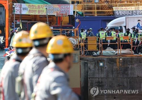 Workers of Daewoo Shipbuilding & Marine Engineering Co. watch police move around striking subcontract workers at the company's Okpo shipyard on Geoje Island, southeastern South Korea, on July 22, 2022. (Yonhap)