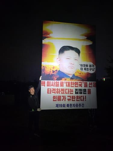 Park Sang-hak, head of the Fighters for a Free North Korea, shows a placard condemning North Korean leader Kim Jong-un in this photo provided by his group. Park claimed he sent balloons carrying the placards and other items to North Korea on Oct. 1. (PHOTO NOT FOR SALE) (Yonhap)
