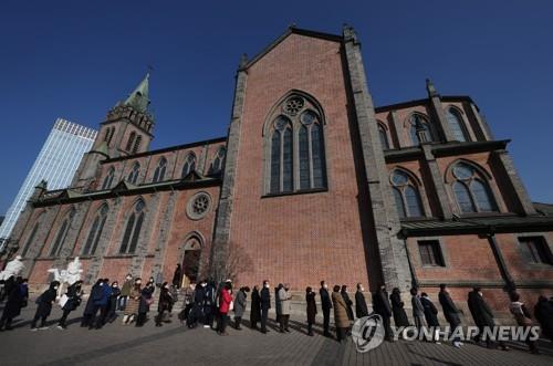 People stand in line to pay tribute to former Pope Benedict XVI at a memorial altar set up in Myeongdong Cathedral in central Seoul on Jan. 1, 2023. (Yonhap)