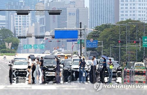 People walk on a sizzling road in Yeouido, Seoul, on July 8, 2025, amid a heat wave warning. (Yonhap)