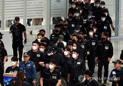 South Korean nationals who had been detained in Cambodia arrive at Incheon International Airport, west of Seoul, under police escort on Oct. 18, 2025. (Pool photo) (Yonhap)
