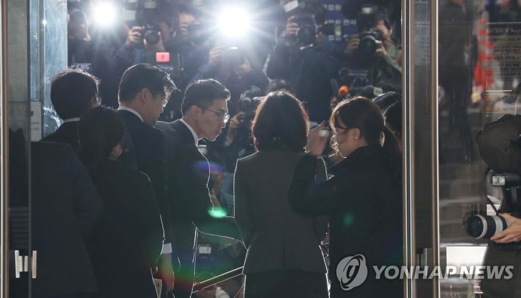 L'épouse de l'ancien ministre de la Justice Cho Kuk (au centre) comparaît devant la Cour centrale du district de Séoul, dans le sud de Séoul, le 23 octobre 2019, pour une audience qui décidera de la délivrance d'un mandat d'arrêt contre elle.
