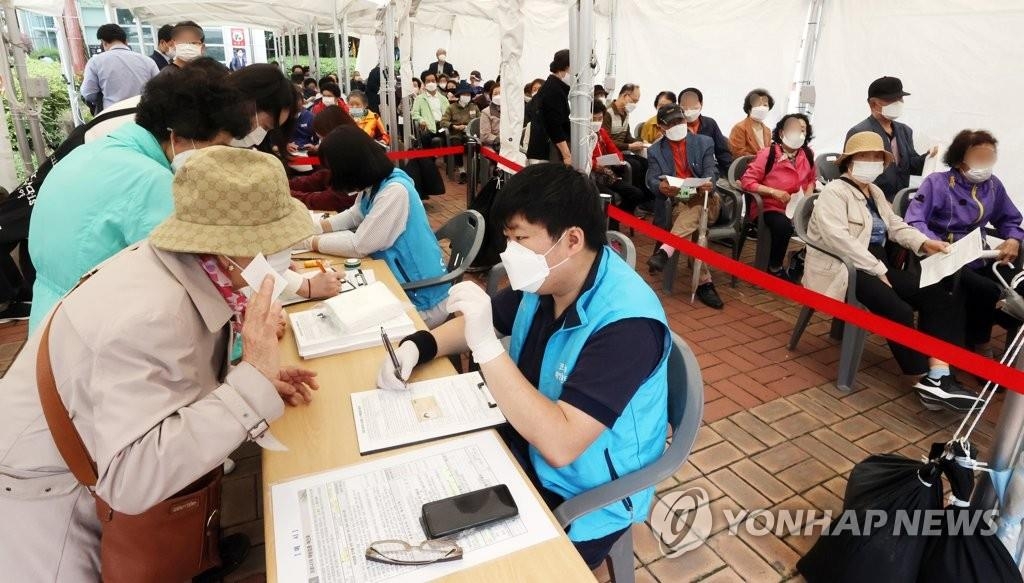 Des personnes font la queue pour recevoir le vaccin contre le nouveau coronavirus (Covid-19) de Pfizer dans un centre médical public installé dans l'ouest de Séoul, le lundi 31 mai 2021.