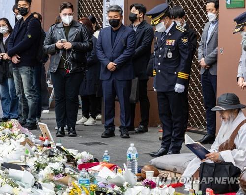 Im Hyun-kyu (en uniforme), nouveau chef de l'agence de police de Yongsan en charge du district d'Itaewon, rend un hommage silencieux devant un autel temporaire pour les victimes de la tragédie d'Itaewon devant la station de métro Itaewon à Séoul, le 3 novembre 2022.