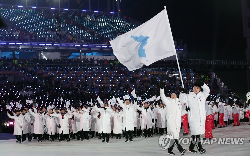 ９日の開会式で朝鮮半島旗を掲げて合同入場する韓国と北朝鮮の選手団＝（聯合ニュース）