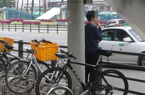 수원역 앞에서 담배 피우는 남성