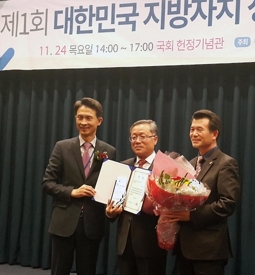 이순근(가운데) 부여군 부군수와 이종관(오른쪽) 경제교통과장이 수상하고 있다.