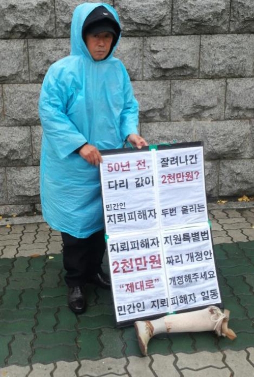 국회 앞에서 지뢰피해자 특별법의 개정을 요구하며 1인 시위하는 지뢰피해자.