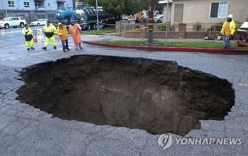 집중호우로 발생한 도로에 대형 `싱크홀'