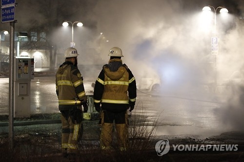 20일 밤 링케뷔 지역 폭동으로 일어난 화재를 진압하는 소방관들