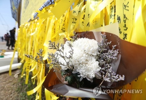 (목포=연합뉴스) 김현태 기자 = 3일 세월호가 정박해 있는 목포 신항만 울타리에 추모객들이 붙인 리본과 국화가 붙어있다. 2017.4.3