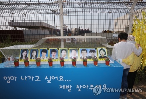 미수습자 사진 뒤로 보이는 세월호 선체
