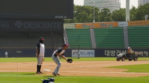 LG 내야수 루이스 히메네스(왼쪽)가 6일 서울 잠실구장에서 검은색 방한용 목보호대로 얼굴을 감싼 채 훈련하고 있다.