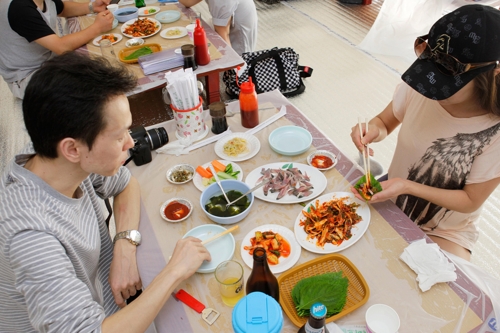 축제장에서 전어무침 먹는 관광객들