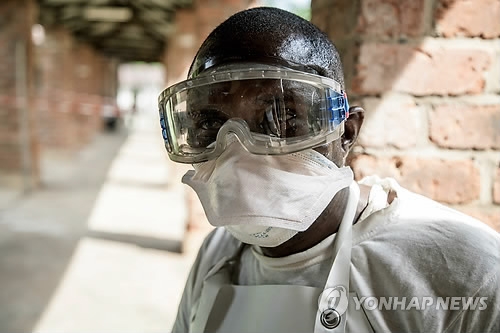 (비코로<민주콩고> AFP=연합뉴스) 민주콩고 북부 에콰테르주 비코로 지역 마을에서 지난 4월 초 이후 출혈열 의심환자 32명이 발생해 이 가운데 14일(현지시간) 현재까지 18명이 사망한 것으로 세계보건기구(WHO)에 보고됐다. 혈액 샘플 검사 결과 이 가운데 2명에게서 에볼라바이러스가 검출돼 확진 환자로 판명됐다. 사진은 에볼라 의심환자들이 격리된 비코로 병원을 방문 중인 한 공중보건 요원이 보호장구를 착용한 모습. bulls@yna.co.kr(끝)