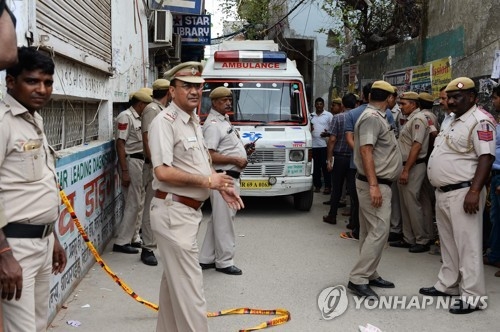 1일 시신 11구가 무더기로 발견된 인도 뉴델리 가정집 근처로 구급차가 들어오고 있다. [AFP=연합뉴스]