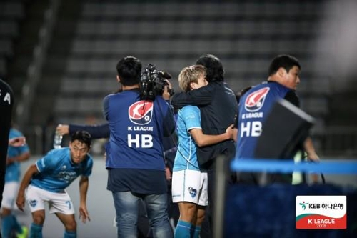 포항의 강상우가 경남전에서 골을 넣고 최순호 감독과 포옹하고 있다.