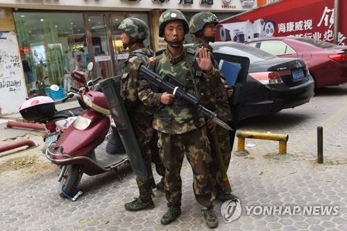 중국 신장 자치주의 한 쇼핑몰 앞에 무장 경찰관들이 서 있다. 
