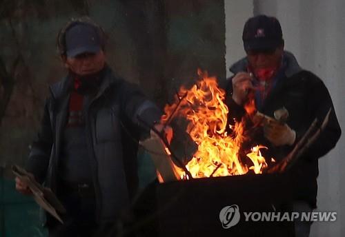 겨울 공사장에서 모닥불 쬐는 노동자