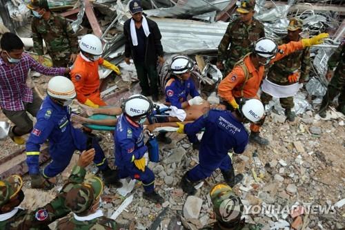 (시아누크빌 AFP=연합뉴스) 현지시간 24일 캄보디아 시아누크빌의 건물 붕괴사고 현장에서 구조대가 생존자를 옮기고 있다.