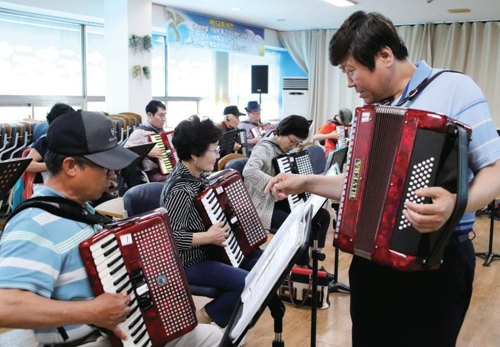 탈북 할머니·할아버지 등에게 아코디언을 가르치고 있는 탈북 예술인 김영남씨.