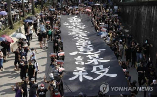 '홍콩 경찰이 짐승처럼 사람을 죽인다'고 쓴 플래카드를 들고 있는 홍콩 시위대