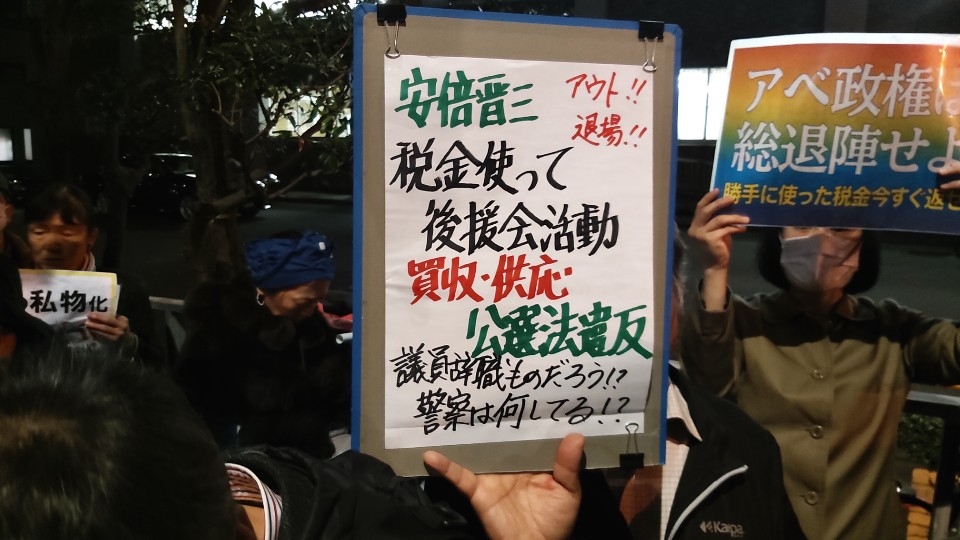 (도쿄=연합뉴스) 18일 저녁 도쿄 일본 수상관저 앞에서 아베 신조 총리의 퇴진을 촉구하는 시위가 펼쳐지고 있다. 한 시위 참가자가 '세금으로 후원회 활동' '공직선거법 위반' 등의 문구가 적힌 손팻말을 들어 보이고 있다. 다른 참가자(오른쪽)는 '아베 정권 총퇴진하라'는 문구의 손팻말을 들고 있다. 