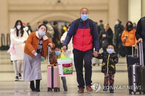 중국 우한 기차역의 마스크 쓴 여행객들