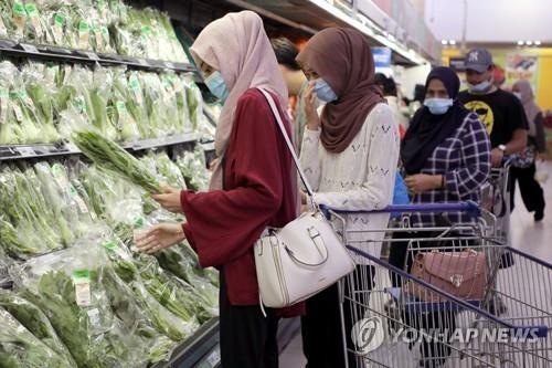 28일 말레이시아 쿠알라룸푸르의 슈퍼마켓에서 마스크를 쓰고 장을 보는 시민. [로이터=연합뉴스]
