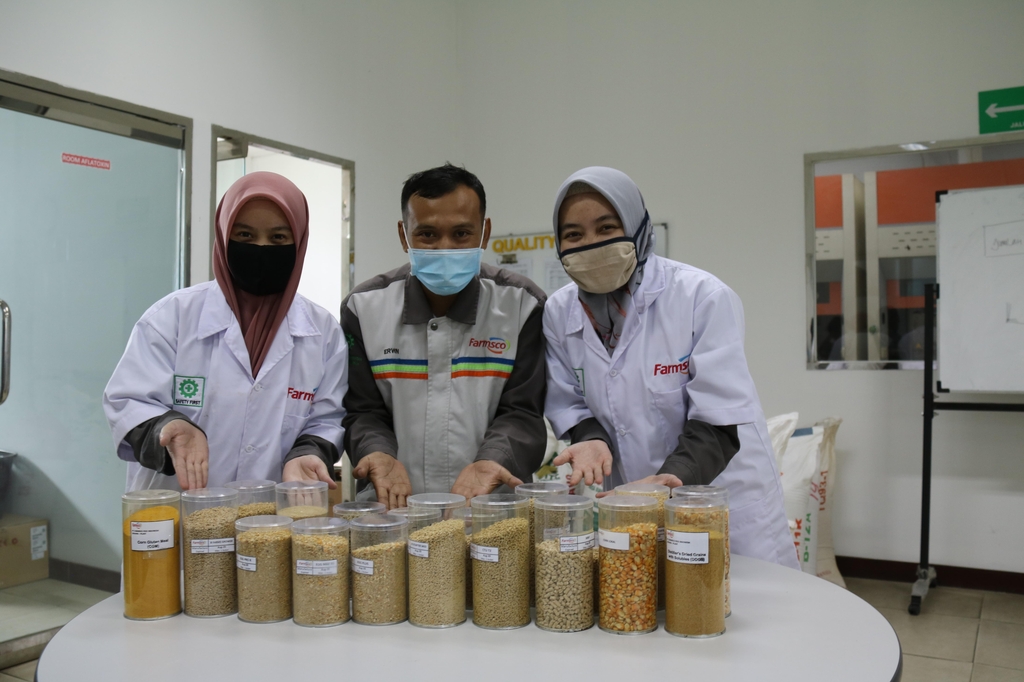 닭 사료 제품 샘플을 보여주는 팜스코 인도네시아인 직원들