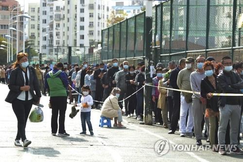 (칭다오 AP=연합뉴스) 지난 12일 중국 산둥성 칭다오의 주거지역 인근에서 마스크를 쓴 시민들이 신종 코로나바이러스 감염증(코로나19) 핵산검사를 받기 위해 길게 줄을 서 있다. 