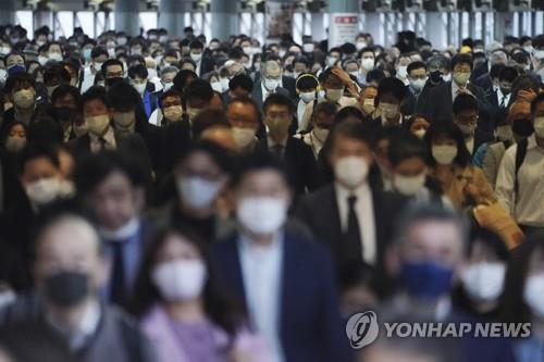 (도쿄 AFP=연합뉴스) 20일 도쿄의 한 역에서 마스크를 쓴 직장인들이 이동하고 있다.