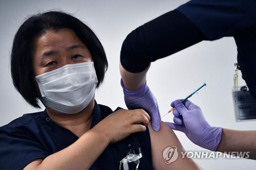 (지바 AFP=연합뉴스) 17일 일본 지바(千葉)현의 한 병원에서 의료 종사자가 화이자의 신종 코로나바이러스 감염증(코로나19) 백신을 맞고 있다.