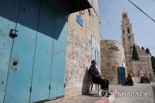 강력한 봉쇄조치 속에 집앞에 나와 앉은 팔레스타인 서안 주민