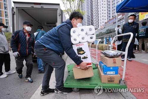 서울 강동구 아파트 앞에서 카트에 짐 옮기는 택배기사