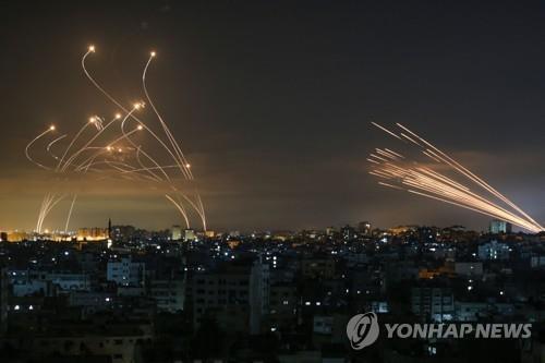 2021년 5월 '11일 전쟁' 당시 가자지구에서 발사된 로켓포탄(오른쪽)과 이를 요격하기 위해 발사된 이스라엘의 아이언 돔 미사일(왼쪽) 궤적. [AFP 연합뉴스 자료사진. 재판매 및 DB 금지]